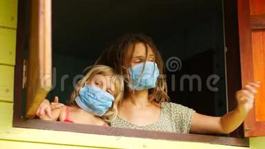 妈妈和女儿戴着防护面具在窗户里。 <strong>传染病</strong>，检疫，病毒。 COVID-19